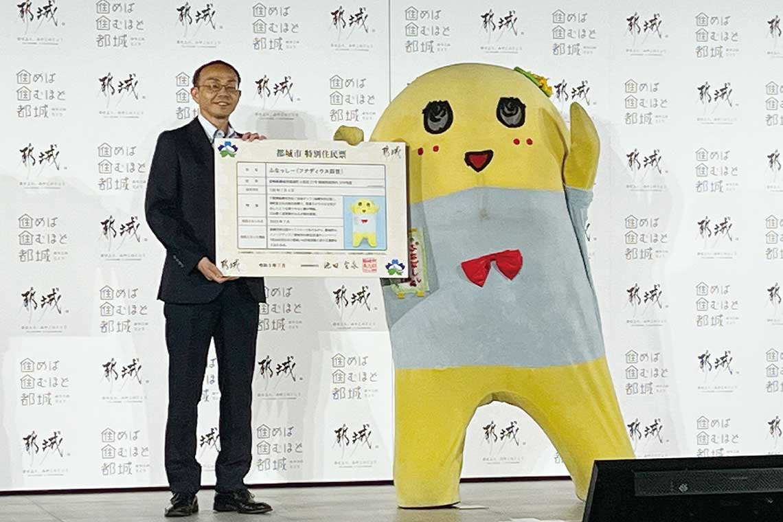 千葉県船橋市の非公認キャラクター、ふなっしーを起用した移住促進キャンペーンでのひとコマ。池田宜永市長から特別の住民票を手渡されて喜ぶふなっしー。
