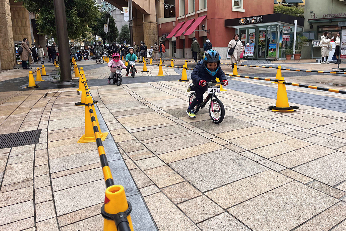 ラチッタデッラの街並みをランニングバイクで走るちびっこ参加者たち（ISF KAWASAKI）／ⒸKAWASAKI CITY