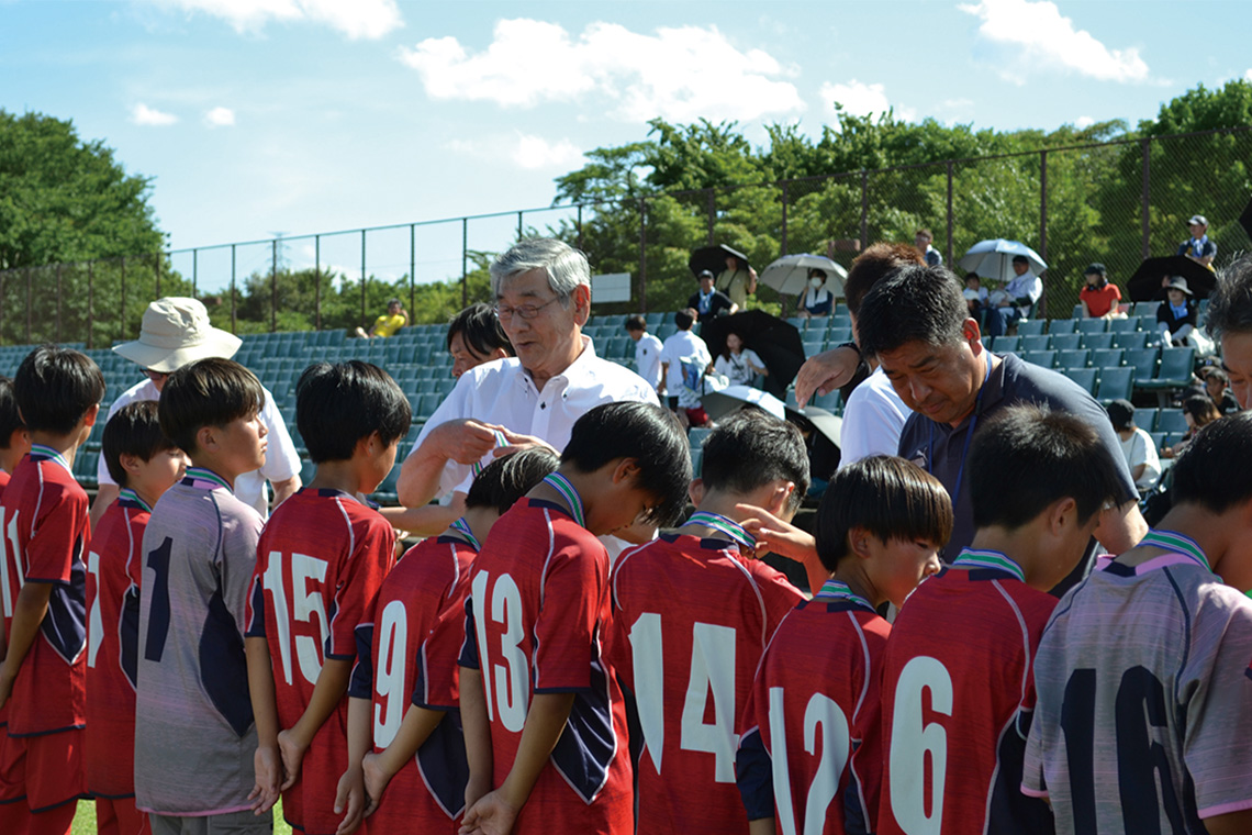 優勝した大分トリニータU-12（大分市）に優勝旗等を渡す石田宣明大分県本部長