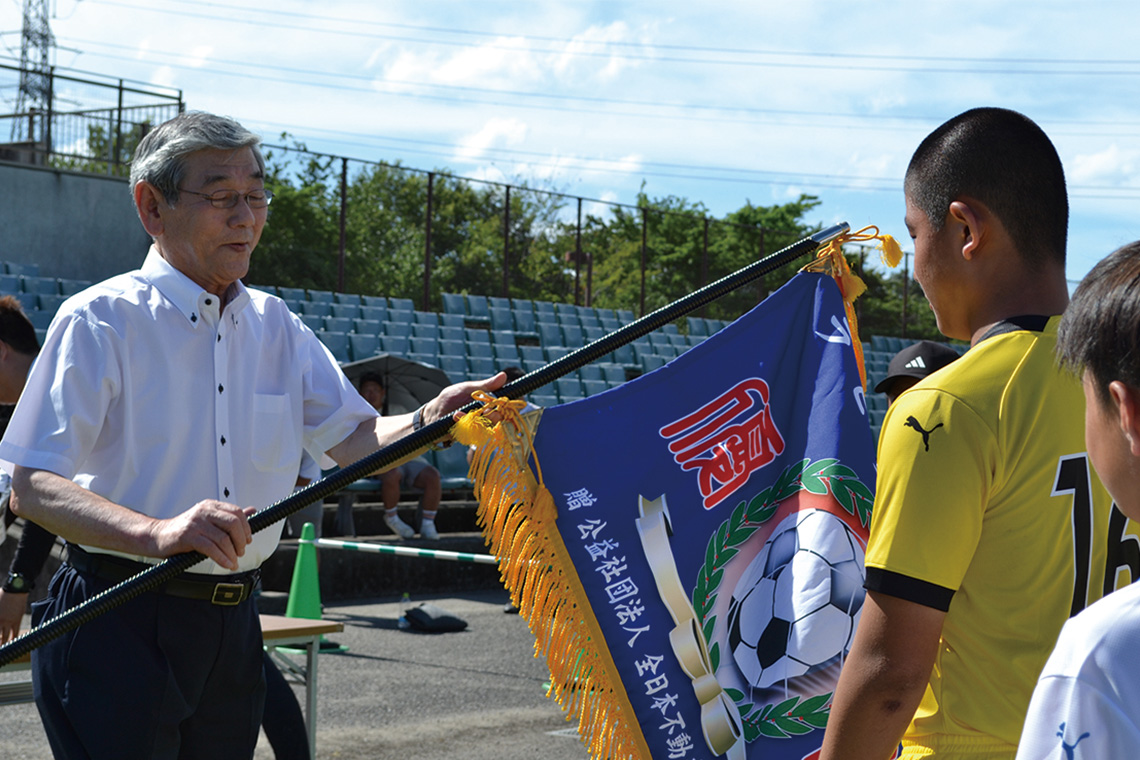 優勝した大分トリニータU-12（大分市）に優勝旗等を渡す石田宣明大分県本部長